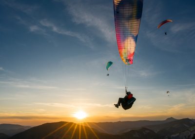 Photos en action - parapentes en vol devant le soleil couchant