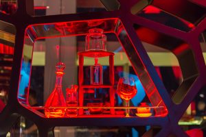 Photos en couleur - Bouteille et verres en rouge dans un bar