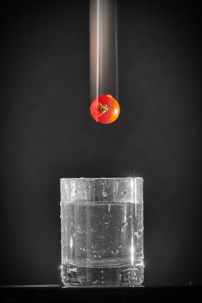 tomate cerise tombant dans un verre d'eau