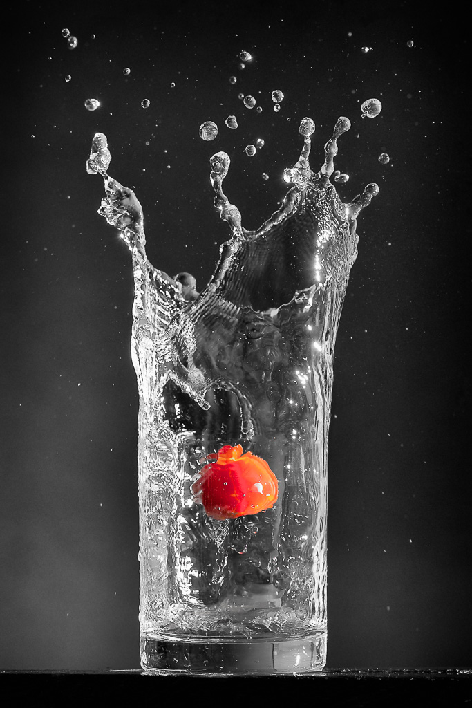 tomate dans un verre d'eau qui jaillit haut sur les bords