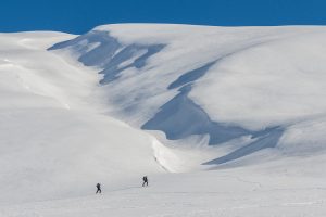 Deux skieurs de randonnée sur fond de neige vierge