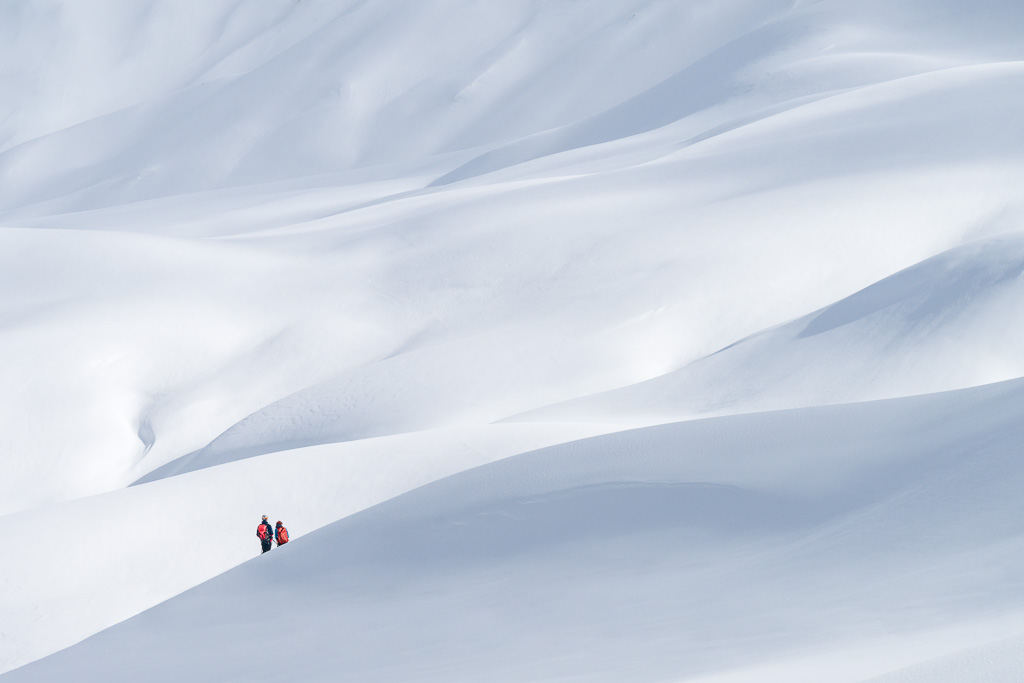skieurs dans un paysage de dunes blanches